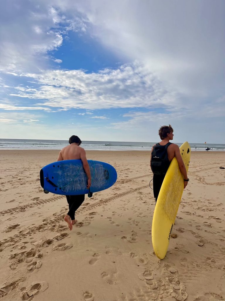 Deux élèves partant à l’eau avec leurs planches en mousse